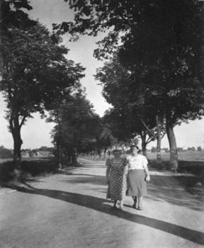 Foto: Auf dem ehemaligen Schulweg Hildegard Tuttlies und Ursel Weinowski. Im Hintergrund auf der linken Seite ist die Schule erkennbar, Quelle: privat